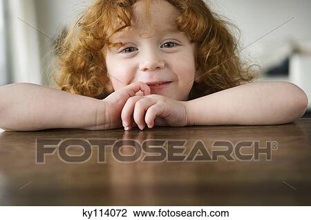 Little girl resting her arms on a coffee table, looking at the camera View Large Photo Image Stock Image - Little girl resting her arms on a coffee table, looking at the camera. Fotosearch