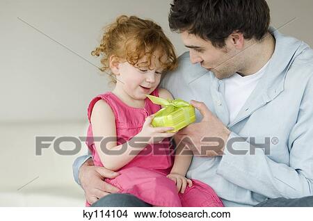 Man giving present to little girl View Large Photo Image Picture - Man giving present to little girl. Fotosearch