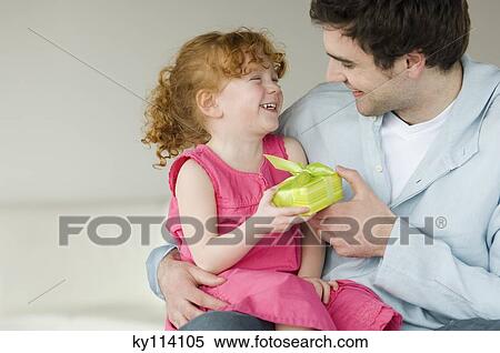 Stock Photography - Man giving present to little girl. Fotosearch