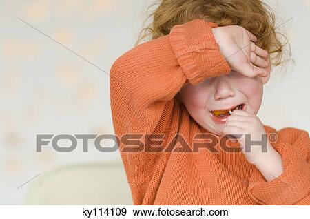 Stock Photo - Portrait of a little girl crying, with arm over eyes. Fotosearch
