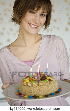 Portrait of a smiling woman holding birthday cake View Large Photo Image Stock Photo - Portrait of a smiling woman holding birthday cake. Fotosearch