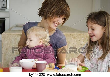 Woman and 2 children at breakfast table View Large Photo Image Stock Photo - Woman and 2 children at breakfast table. Fotosearch