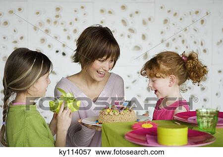 Stock Photo - Woman and 2 little girls with birthday cake. Fotosearch