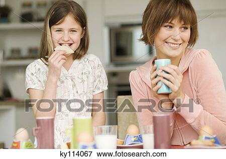 Woman and little girl at breakfast table View Large Photo Image Stock Photo - Woman and little girl at breakfast table. Fotosearch