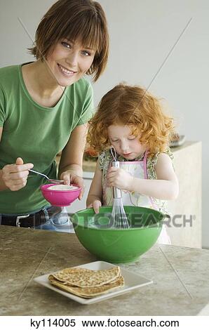 Stock Photography - Woman and little girl cooking. Fotosearch