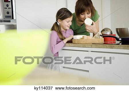 Woman and little girl in the kitchen, preparing cheese tray View Large Photo Image Stock Photo - Woman and little girl in the kitchen, preparing cheese tray. Fotosearch