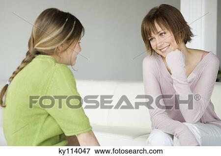 Woman and little girl talking, sitting in living-room View Large Photo Image Stock Photo - Woman and little girl talking, sitting in living-room. Fotosearch
