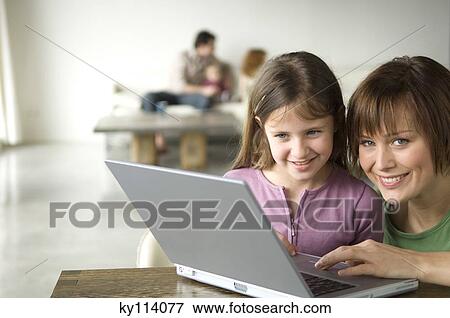 Stock Photo - Woman and little girl using laptop computer. Fotosearch