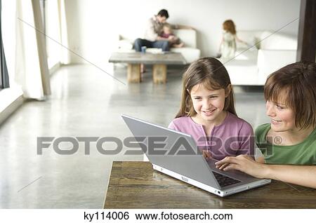 Woman and little girl using laptop computer, man and 2 children in the background View Large Photo Image Stock Photograph - Woman and little girl using laptop computer, man and 2 children in the background. Fotosearch