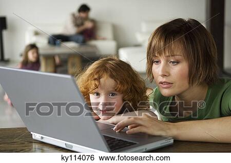 Woman and little girl using laptop computer View Large Photo Image Stock Photograph - Woman and little girl using laptop computer. Fotosearch