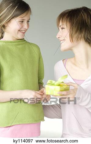 Stock Photo - Woman giving present to little girl. Fotosearch