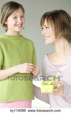 Woman giving present to little girl View Large Photo Image Stock Photo - Woman giving present to little girl. Fotosearch