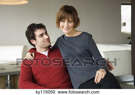Stock Image - Couple embracing in a living-room. Fotosearch