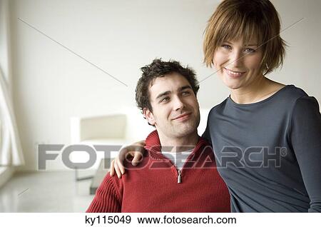 Stock Photo - Couple embracing in a living-room. Fotosearch