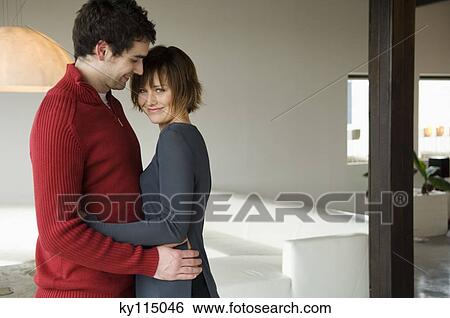 Couple embracing in a living-room View Large Photo Image Stock Photograph - Couple embracing in a living-room. Fotosearch