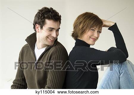 Smiling couple sitting back to back View Large Photo Image Picture - Smiling couple sitting back to back. Fotosearch