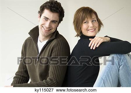 Smiling couple sitting back to back View Large Photo Image Stock Photo - Smiling couple sitting back to back. Fotosearch
