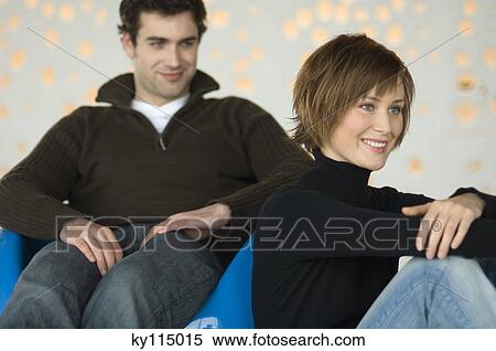 Smiling couple sitting in living-room View Large Photo Image Stock Photography - Smiling couple sitting in living-room. Fotosearch