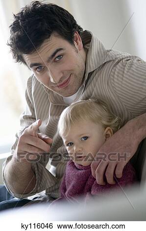 Man and little boy posing for the camera View Large Photo Image Stock Photograph - Man and little boy posing for the camera. Fotosearch