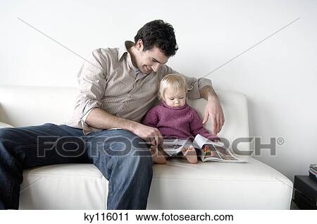 Man and little boy reading, sitting on a sofa View Large Photo Image Stock Image - Man and little boy reading, sitting on a sofa. Fotosearch