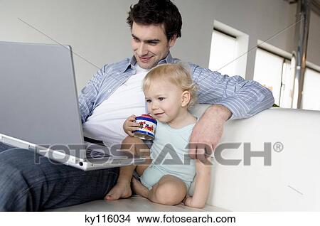Man and little boy using laptop computer View Large Photo Image Picture - Man and little boy using laptop computer. Fotosearch