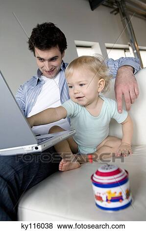 Man and little boy using laptop computer View Large Photo Image Stock Photo - Man and little boy using laptop computer. Fotosearch