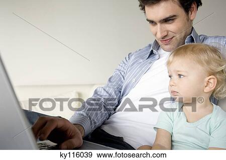 Man and little boy using laptop computer View Large Photo Image Stock Photo - Man and little boy using laptop computer. Fotosearch