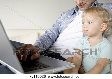 Man and little boy using laptop computer View Large Photo Image Stock Photograph - Man and little boy using laptop computer. Fotosearch