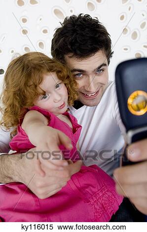 Man and little girl taking picture with camera phone View Large Photo Image Stock Photography - Man and little girl taking picture with camera phone. Fotosearch