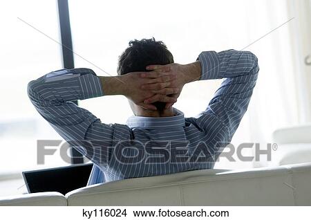 Man resting on a sofa, rear viiew View Large Photo Image Picture - Man resting on a sofa, rear viiew. Fotosearch