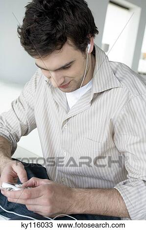 Man using iPod View Large Photo Image Stock Image - Man using iPod. Fotosearch