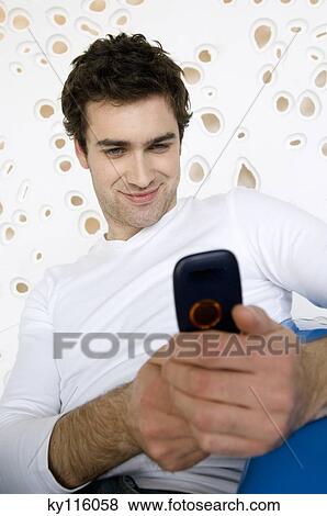 Smiling man taking picture with camera phone View Large Photo Image Stock Photo - Smiling man taking picture with camera phone. Fotosearch