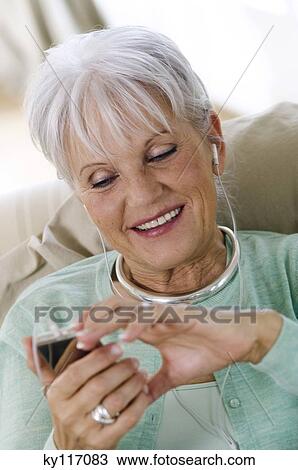 Portrait of a senior woman listening to MP3 player View Large Photo Image Stock Image - Portrait of a senior woman listening to MP3 player. Fotosearch