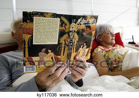 Senior Couple In Bed Woman Sleeping Man Reading Kama Sutra Book Stock Photograph Ky117036 Fotosearch