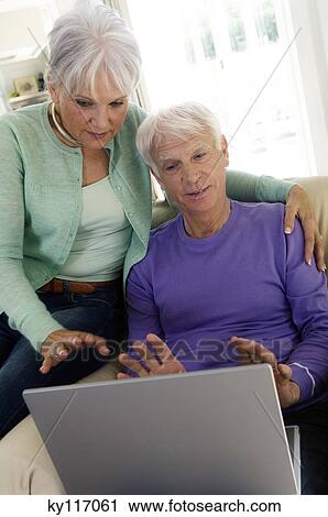 Senior couple using a laptop computer View Large Photo Image Stock Image - Senior couple using a laptop computer. Fotosearch