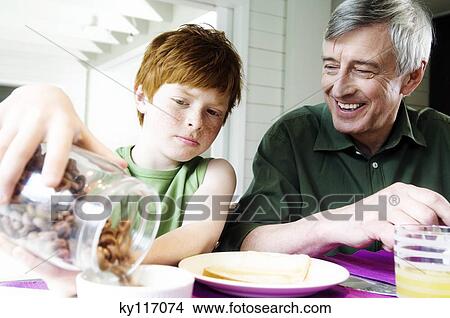 Senior man and boy having breakfast View Large Photo Image Picture - Senior man and boy having breakfast. Fotosearch