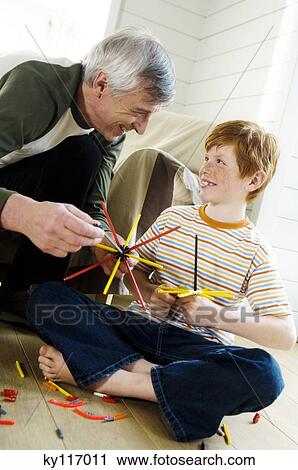 Senior man and boy playing construction game indoors View Large Photo Image Stock Image - Senior man and boy playing construction game indoors. Fotosearch