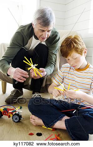 Senior man and boy playing construction game indoors View Large Photo Image Stock Image - Senior man and boy playing construction game indoors. Fotosearch
