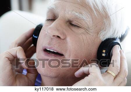 Senior man wearing headphones, eyes shut, close-up View Large Photo Image Stock Photo - Senior man wearing headphones, eyes shut, close-up. Fotosearch