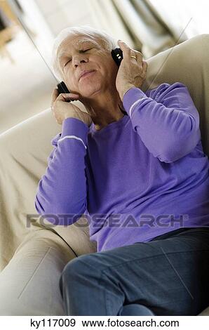 Senior man wearing headphones, sitting in an armchair View Large Photo Image Stock Photo - Senior man wearing headphones, sitting in an armchair. Fotosearch
