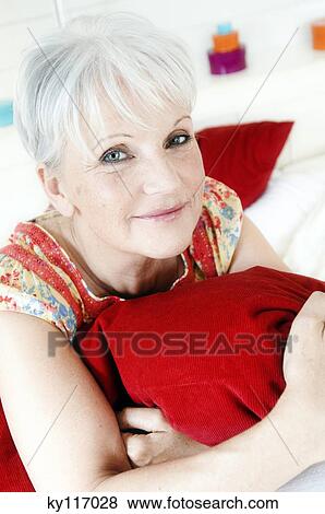 Stock Photo - Senior woman holding a pillow tightly to her. Fotosearch