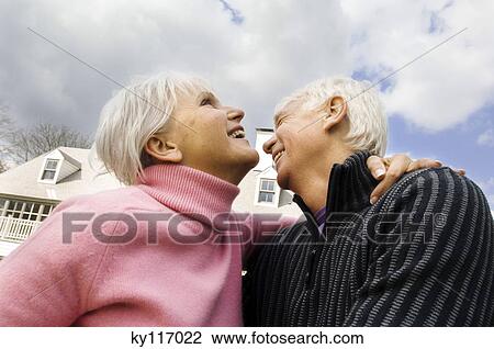 Smiling senior couple embracing outdoors, low angle View Large Photo Image Stock Image - Smiling senior couple embracing outdoors, low angle. Fotosearch