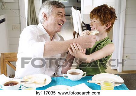 Smiling senior man and boy having breakfast View Large Photo Image Stock Photography - Smiling senior man and boy having breakfast. Fotosearch