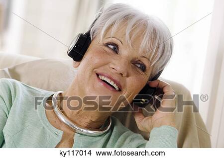 Smiling senior woman wearing headphones View Large Photo Image Picture - Smiling senior woman wearing headphones. Fotosearch