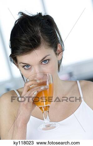 Portrait of a woman drinking orange juice View Large Photo Image Stock Image - Portrait of a woman drinking orange juice. Fotosearch