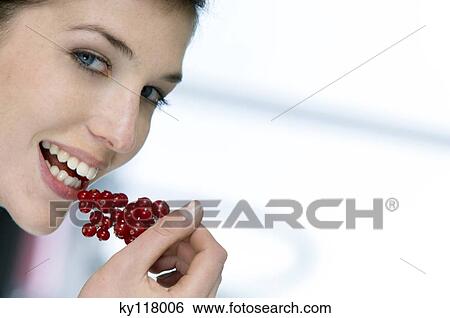 Portrait of a woman eating redcurrants View Large Photo Image Stock Photograph - Portrait of a woman eating redcurrants. Fotosearch