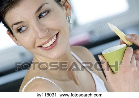 Portrait of a young smiling woman holding bowl of sauce and mini corn View Large Photo Image Stock Image - Portrait of a young smiling woman holding bowl of sauce and mini corn. Fotosearch
