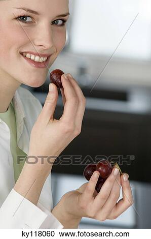 Portrait of a young smiling woman eating red grapes View Large Photo Image Stock Image - Portrait of a young smiling woman eating red grapes. Fotosearch