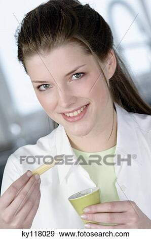 Portrait of a young smiling woman holding bowl of sauce and mini corn View Large Photo Image Stock Photo - Portrait of a young smiling woman holding bowl of sauce and mini corn. Fotosearch