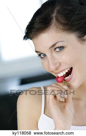 Portrait of a young smiling woman biting into a radish View Large Photo Image Stock Photo - Portrait of a young smiling woman biting into a radish. Fotosearch